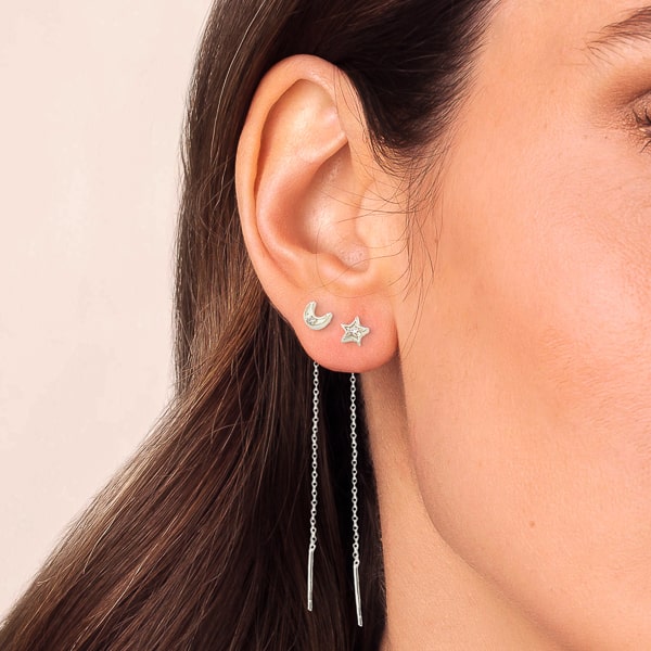 Woman wearing silver moon and star threader earrings