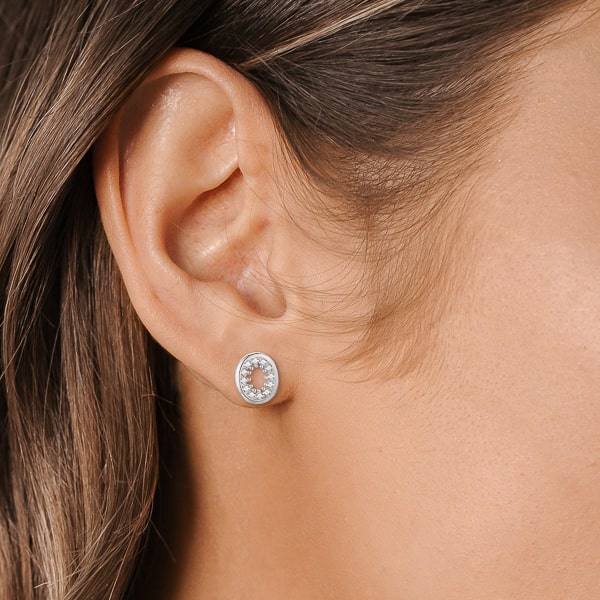 Woman wearing silver oval crystal halo stud earrings