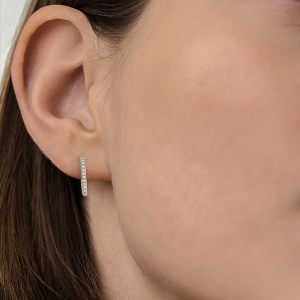 Woman wearing silver oval crystal hoop earrings