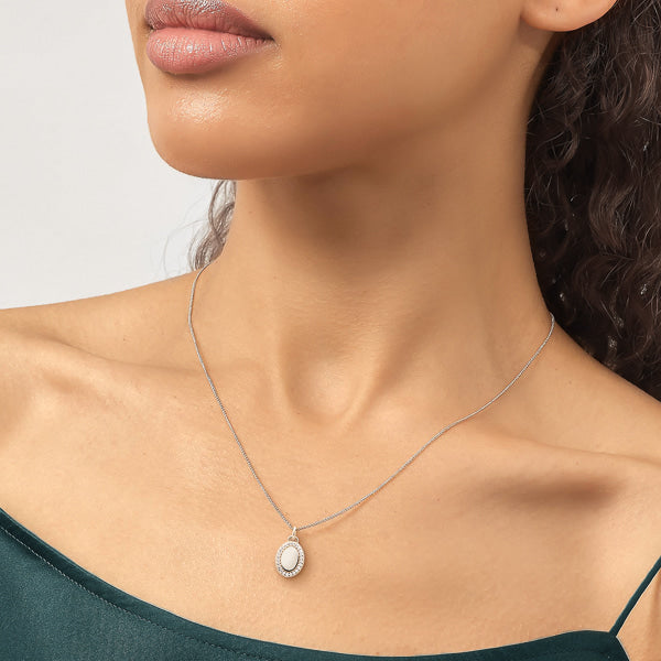 Woman wearing silver oval pendant necklace