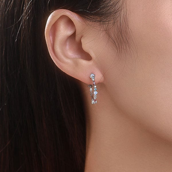 Woman wearing silver red and blue crystal open hoop earrings