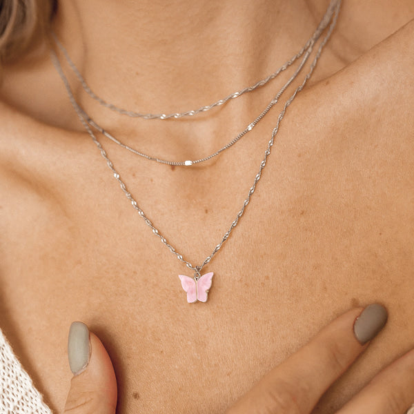 Woman wearing a silver rose pink butterfly pendant necklace