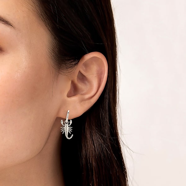 Woman wearing silver scorpion hoop earrings