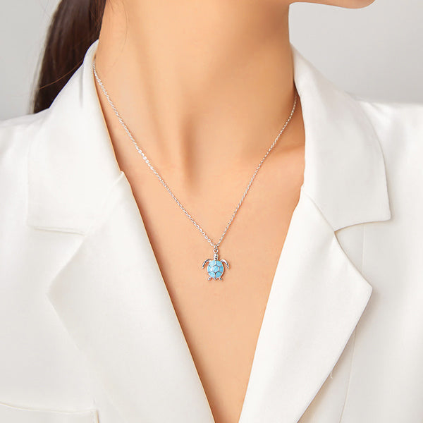 Woman wearing a blue sea turtle pendant on a silver necklace