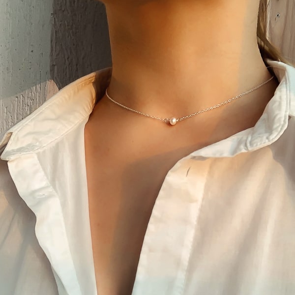Silver chain choker necklace with one 4mm freshwater pearl on woman's neck
