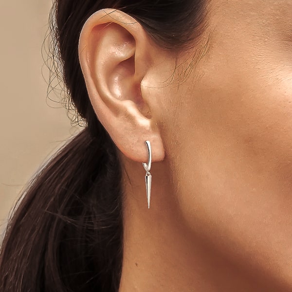 Woman wearing silver single spike hoop earrings