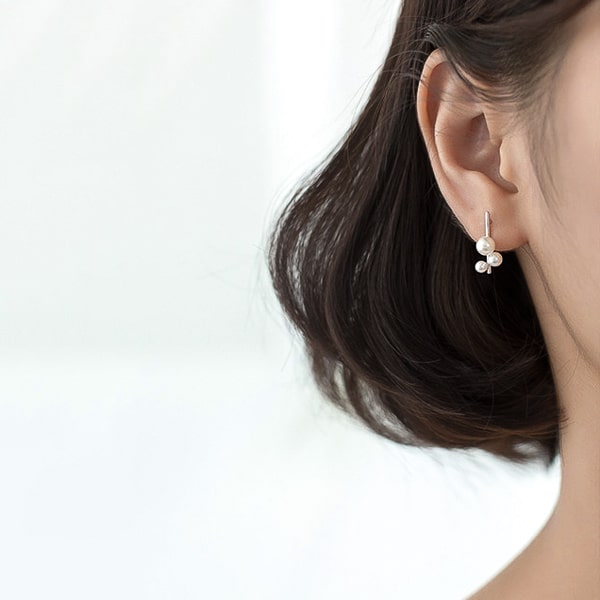 Model wearing silver triple pearl bar stud earrings