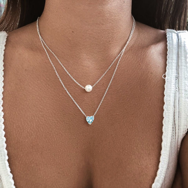Woman wearing a silver turquoise crystal heart necklace
