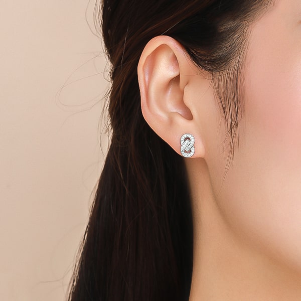 Woman wearing silver vertical infinity crystal stud earrings