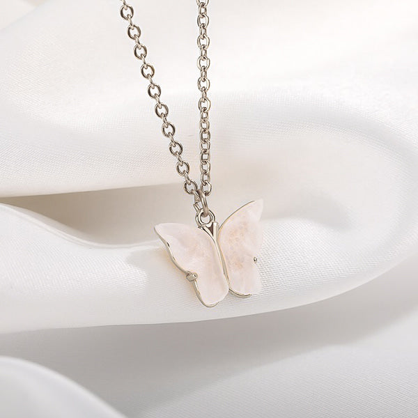 White butterfly on a silver necklace display