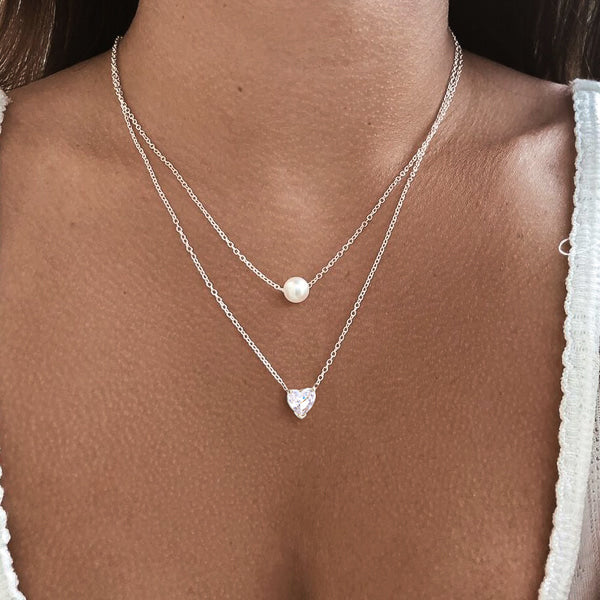 Woman wearing a silver white crystal heart necklace