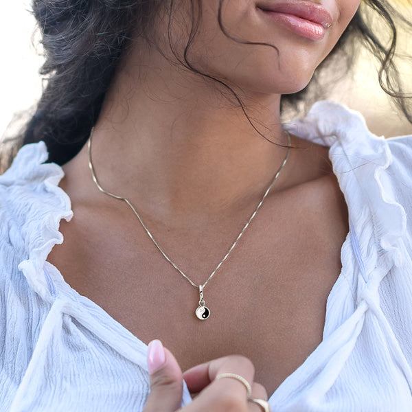 Woman wearing silver yin yang necklace