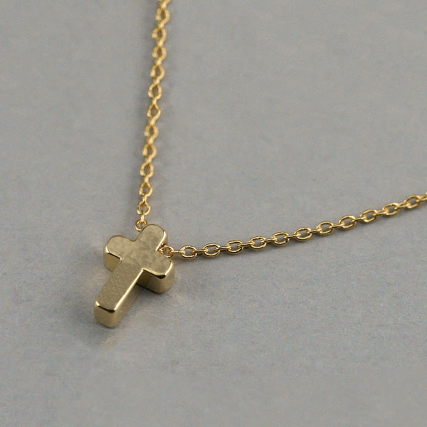 Small gold cross necklace display