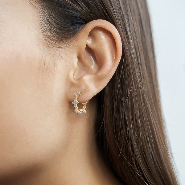 Woman wearing gold floral hoop earrings