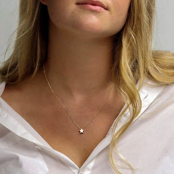Woman wearing a small gold star necklace
