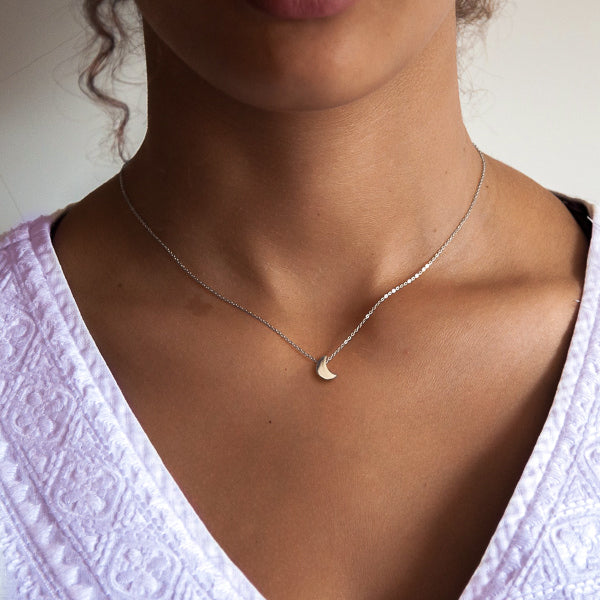 Woman wearing a small silver moon necklace