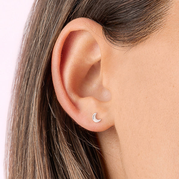 Small silver moon stud earrings on woman