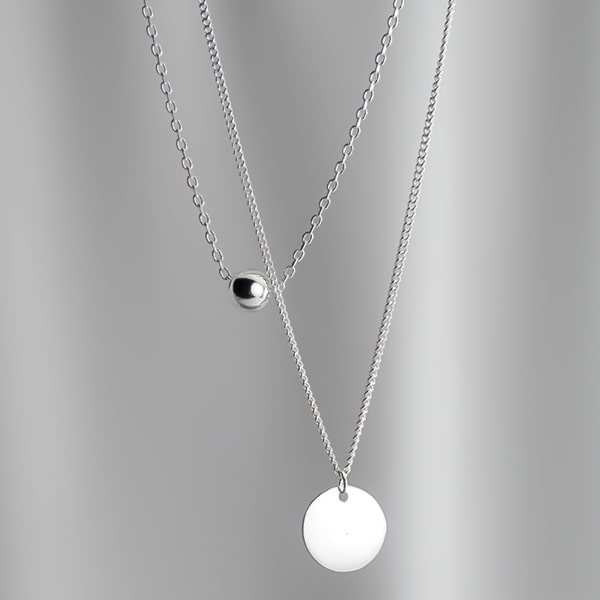 Layered sterling silver necklace with ball and coin pendants