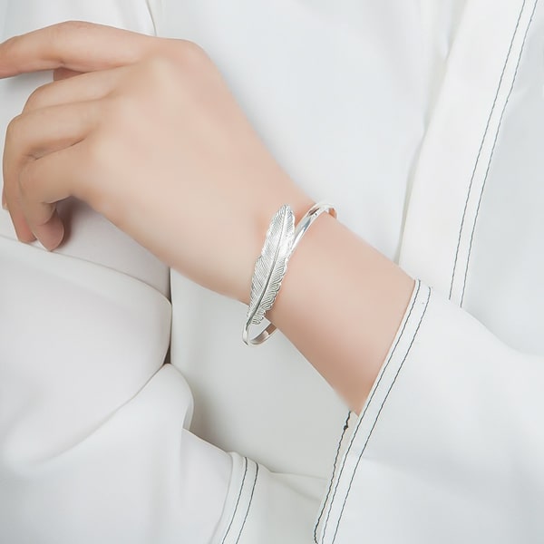 Sterling silver feather cuff bracelet on a woman's wrist