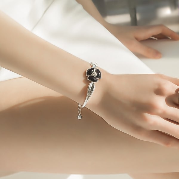 Sterling silver flower bangle bracelet on a woman's wrist