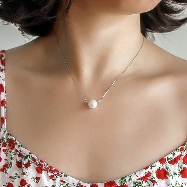 9-10mm pearl necklace with a sterling silver chain on woman's neck