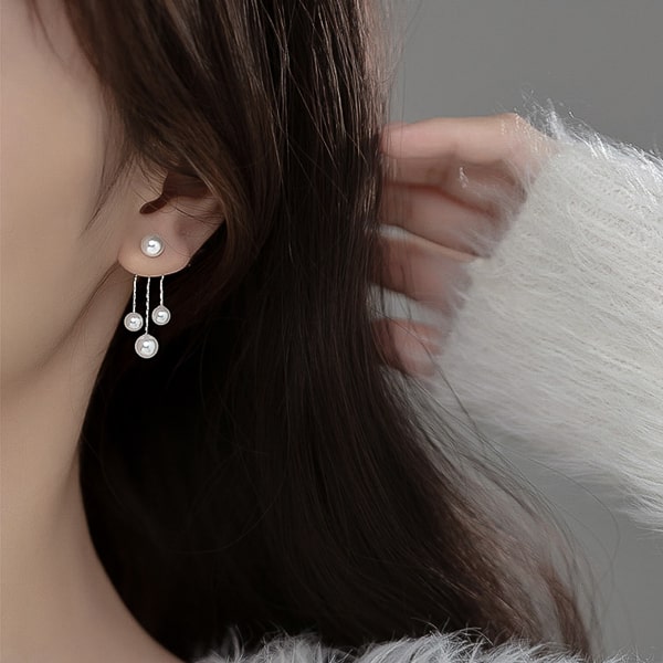 Three pearl dangle earrings on model