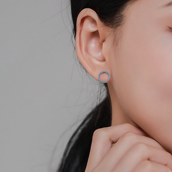 Woman wearing turquoise circle stud earrings
