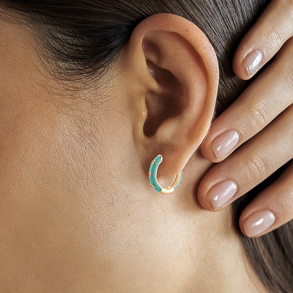 Woman wearing turquoise enamel mini hoop earrings