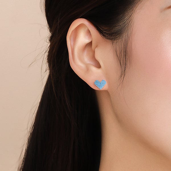 Model wearing turquoise heart stud earrings