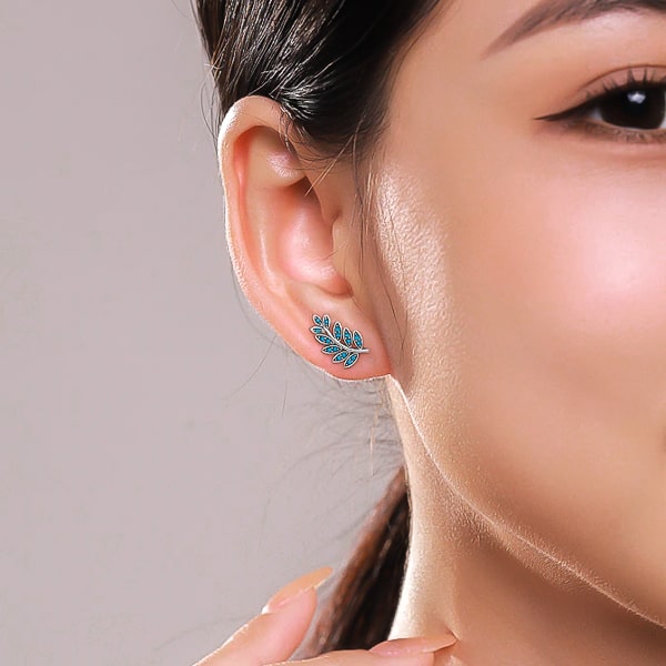 Woman wearing turquoise leaf stud earrings