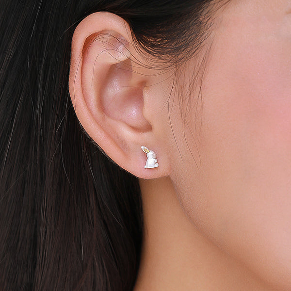 Two-tone bunny rabbit stud earrings on woman's ear