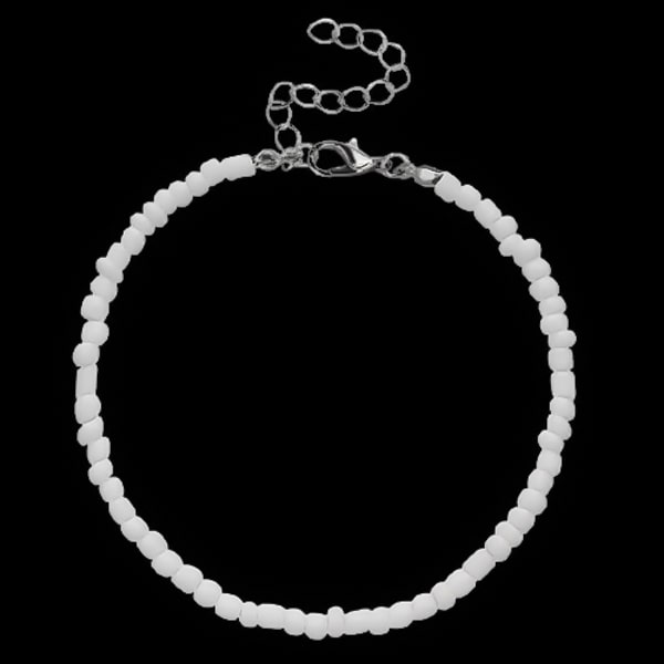 White handmade beaded ankle bracelet on black background