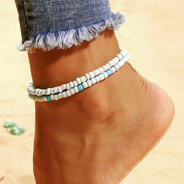 White handmade beaded anklet on a womans ankle